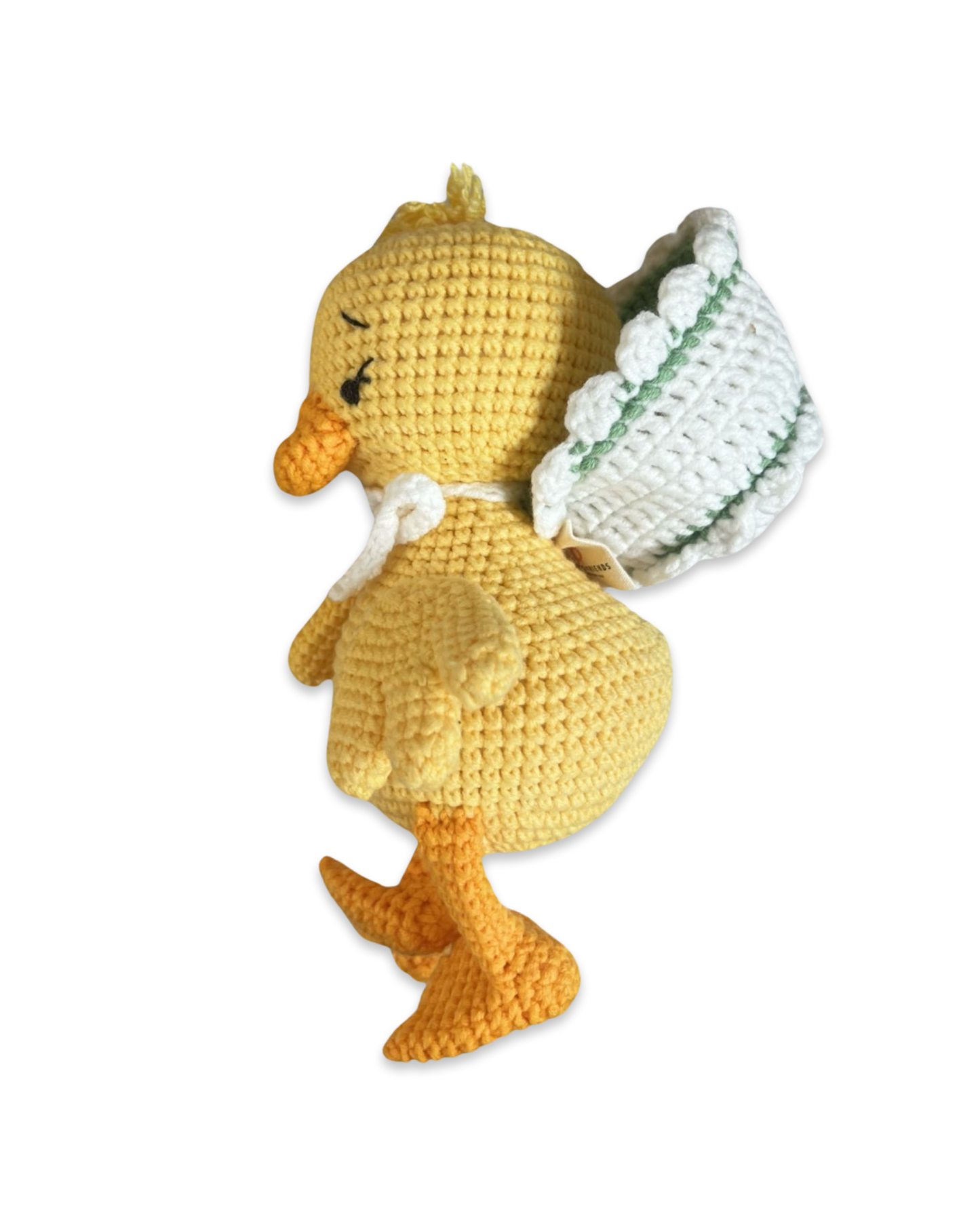Side view of a handmade crochet duck plush toy wearing a soft bonnet by Knitted Friends