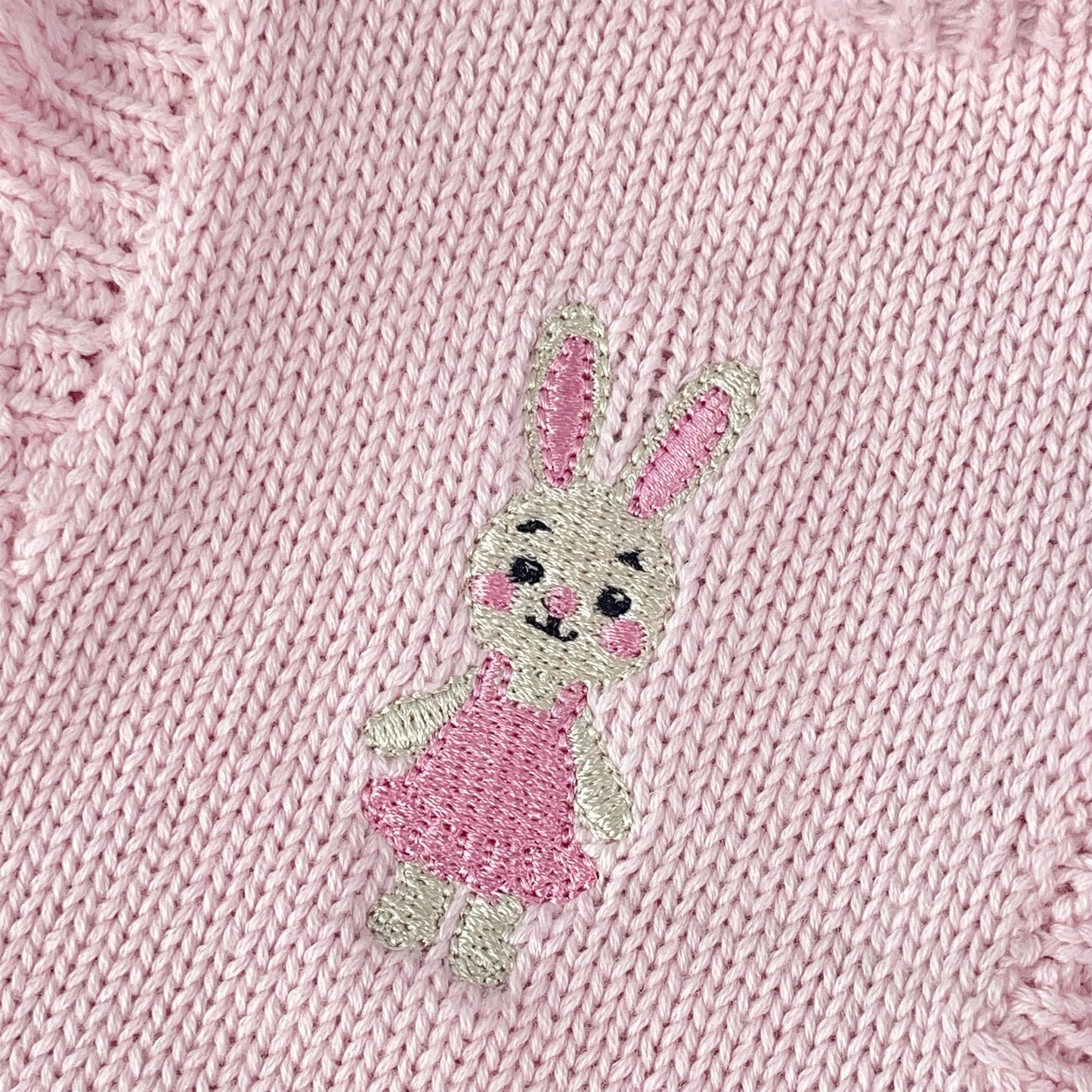 Knitted Friends pink baby tutu romper with ruffle straps, layered skirt, and embroidered bunny detail, displayed on a soft neutral background
