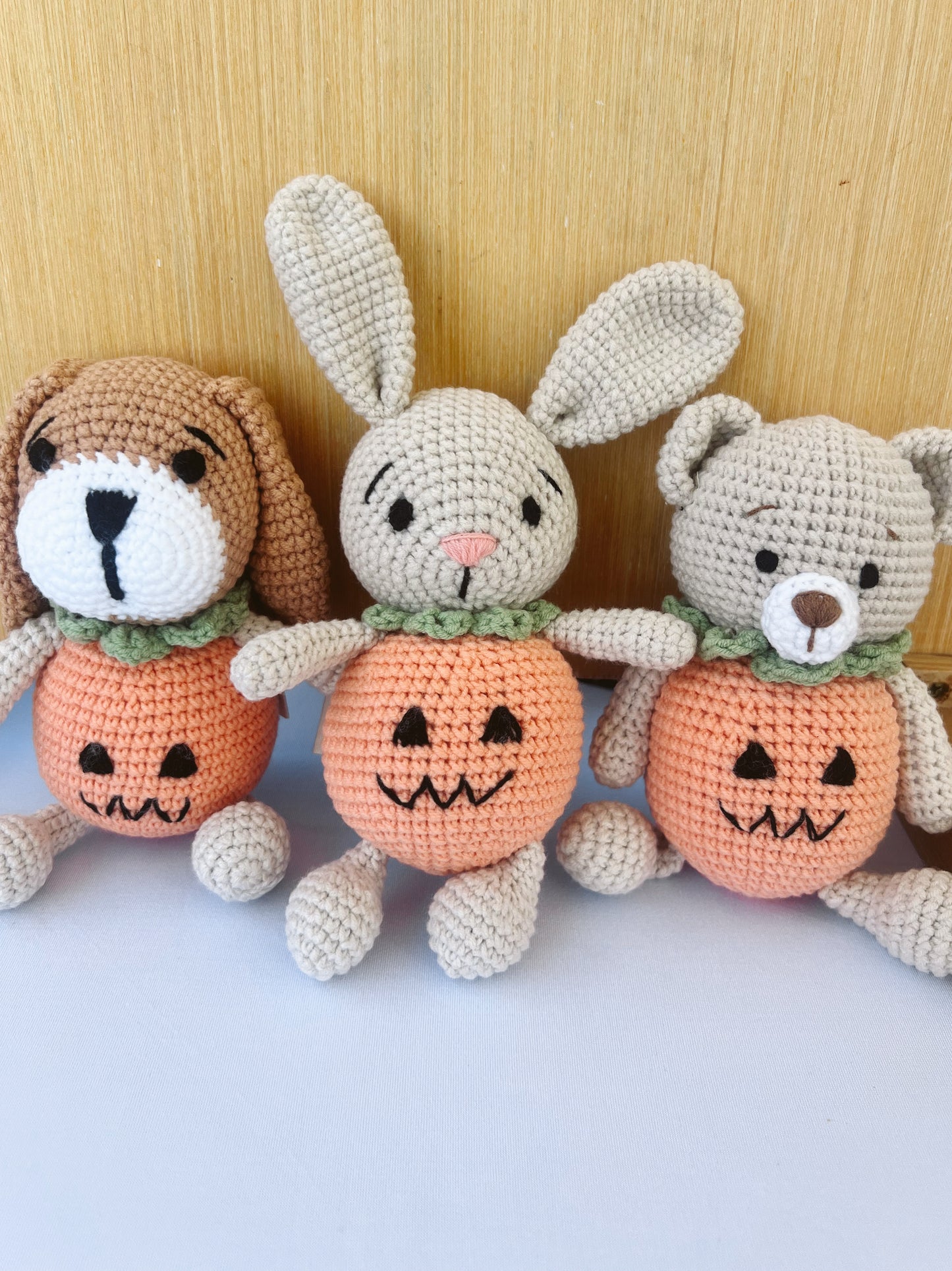 Knitted Friends pumpkin bunny doll with crochet bunny ears and pumpkin body, displayed on a black background
