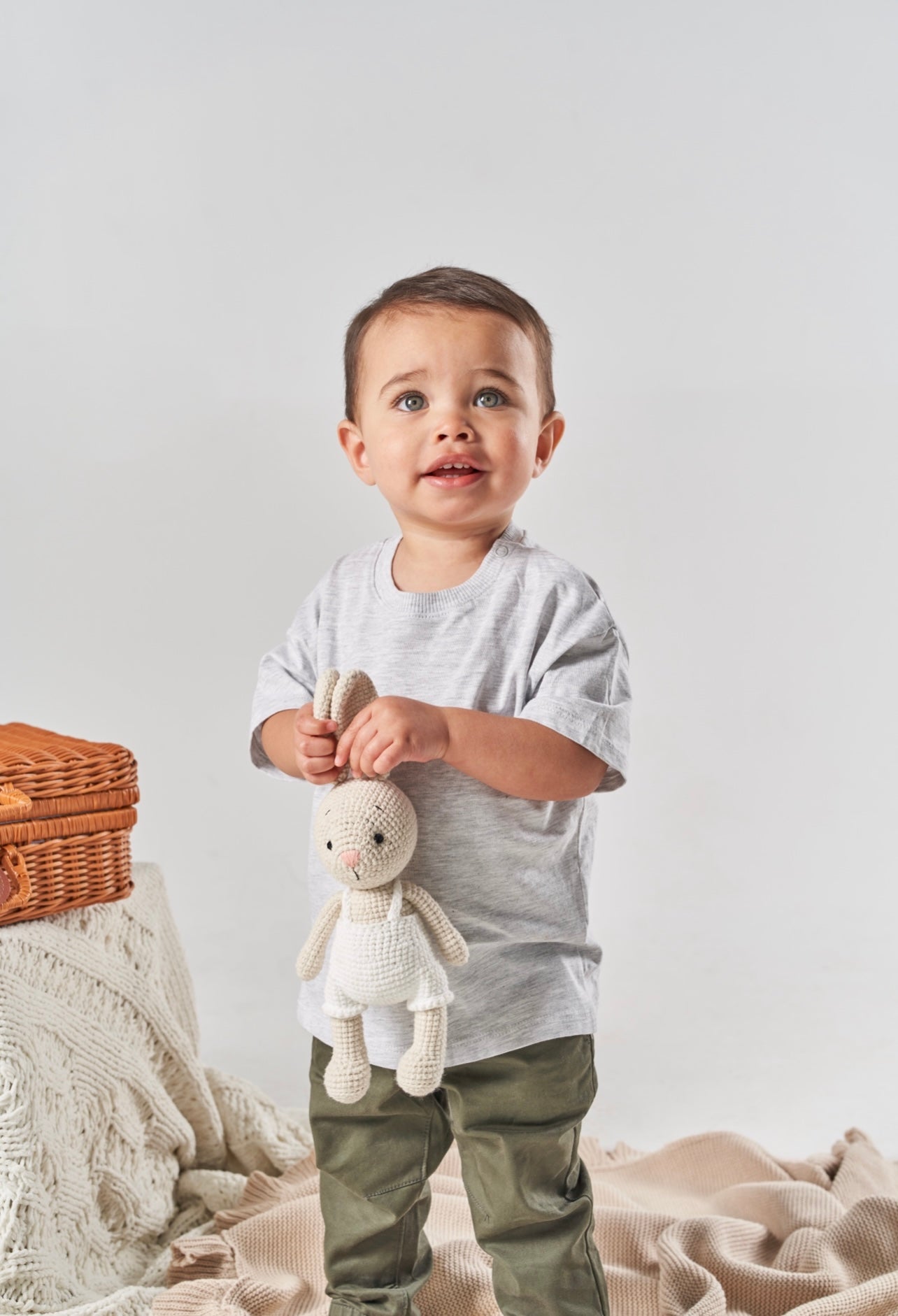 LITTLE BOY HOLDING BUNNY DOLL BY THE FLOPPY EARS 