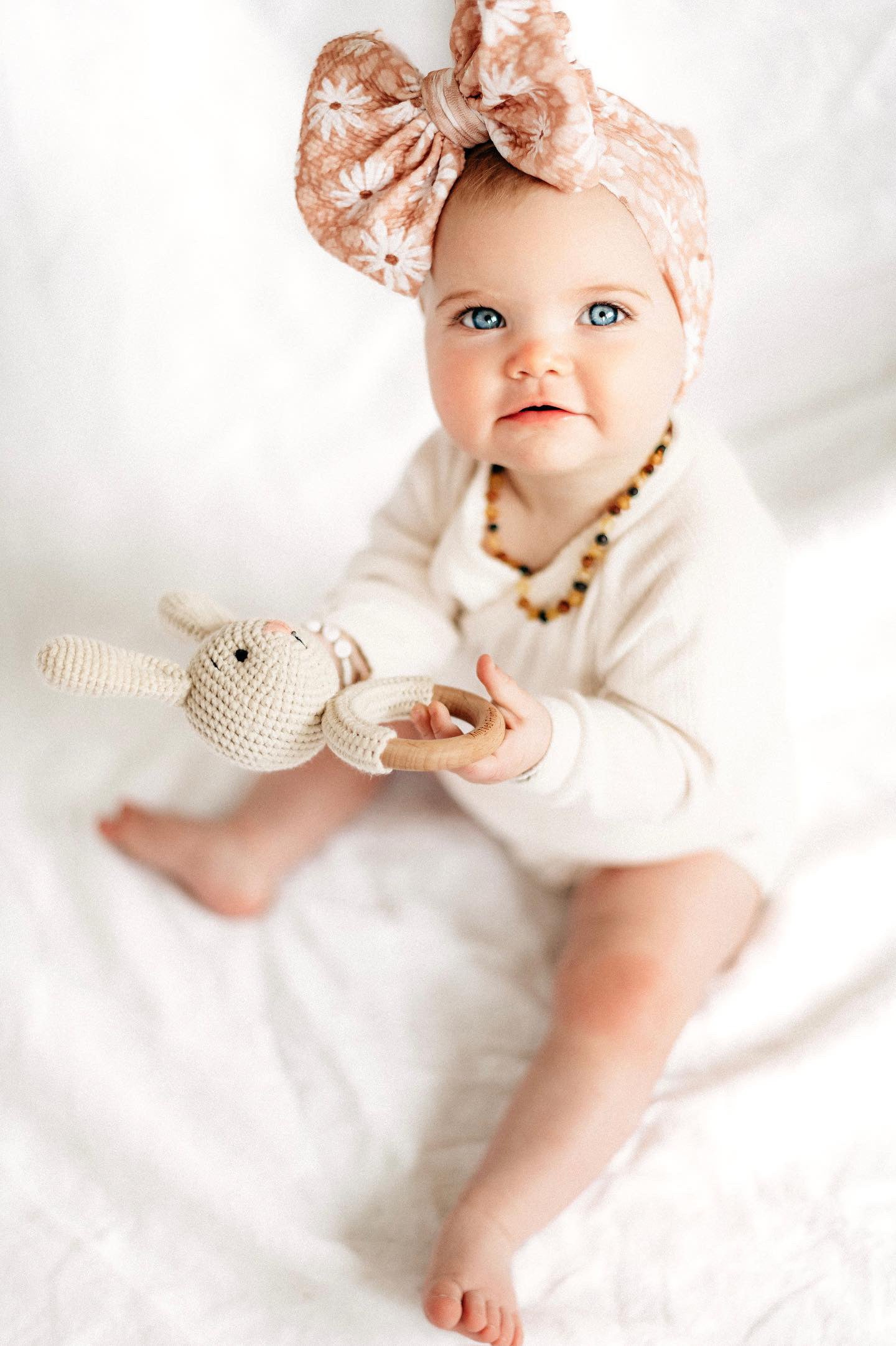 Baby holding bunny rattle 