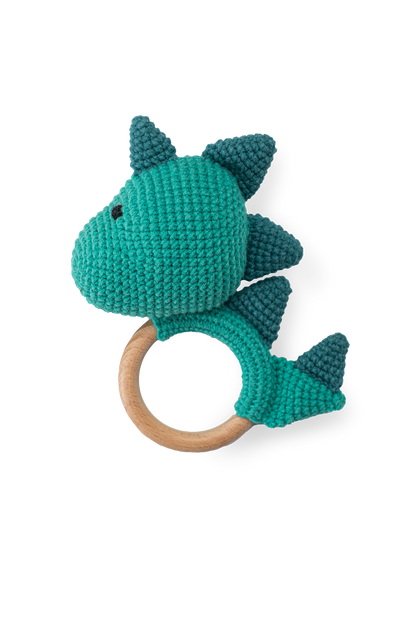 Handmade teal crochet dinosaur teether toy with smooth natural wooden ring by Knitted Friends, featuring detailed dark teal scales, isolated on a clean black background.
