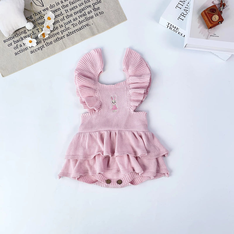 Knitted Friends pink baby tutu romper with ruffle straps, layered skirt, and embroidered bunny detail, displayed on a soft neutral background