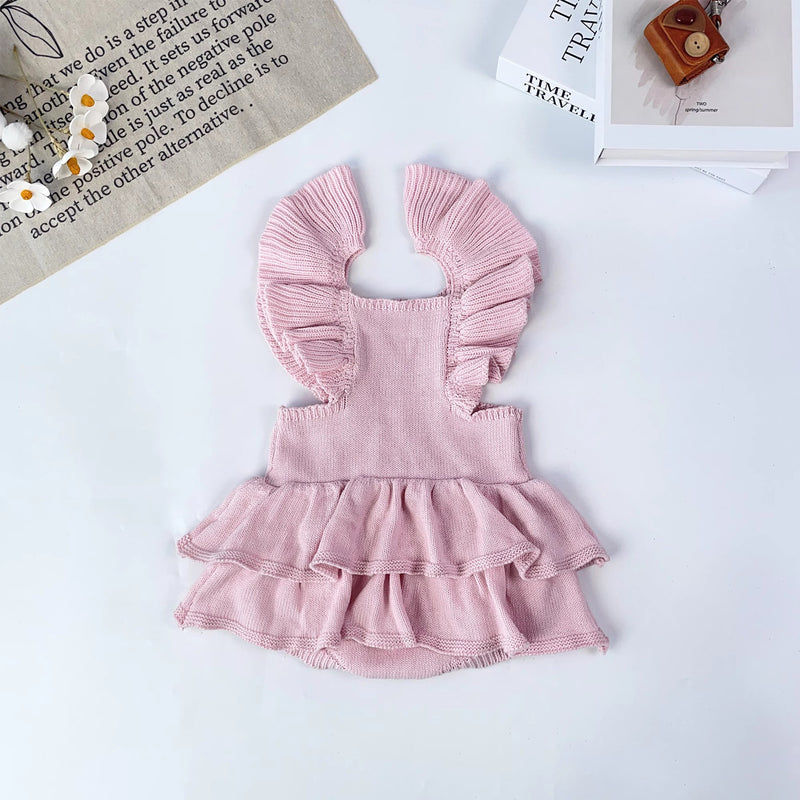 Knitted Friends pink baby tutu romper with ruffle straps, layered skirt, and embroidered bunny detail, displayed on a soft neutral background