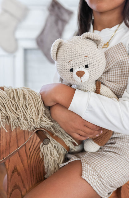 Child holding handmade crochet teddy bear toy crafted by Knitted Friends