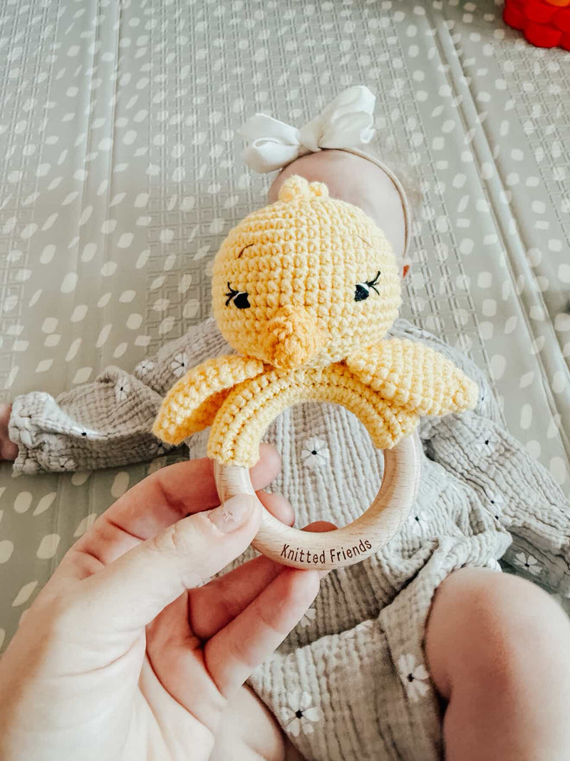 Hand holding a knitted chick rattle made by Knitted Friends