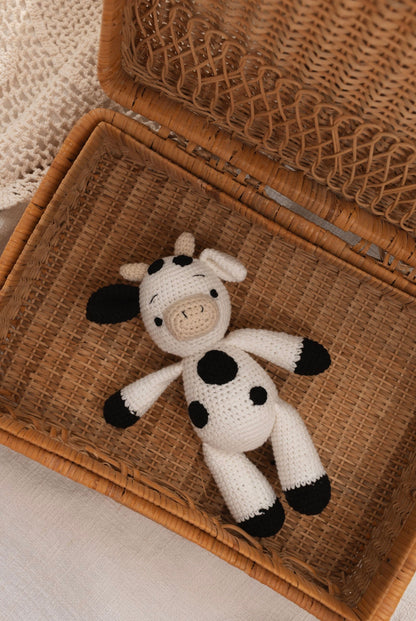Close-up of a handmade crochet cow doll by Knitted Friends inside a basket