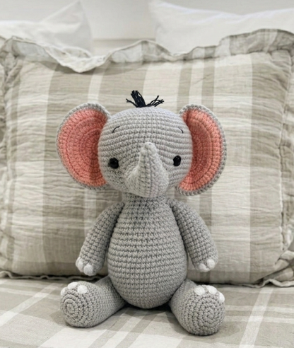 Handmade crochet elephant plush toy by Knitted Friends with soft grey yarn, pink-lined ears