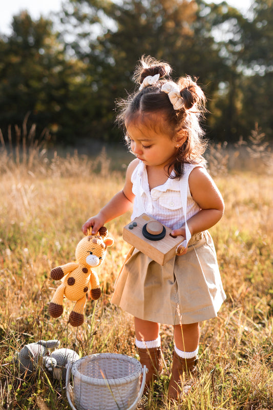 Girl holding a handmade knitted giraffe doll by Knitted Friends