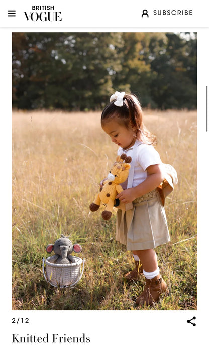Baby with a handmade crochet giraffe doll by Knitted Friends