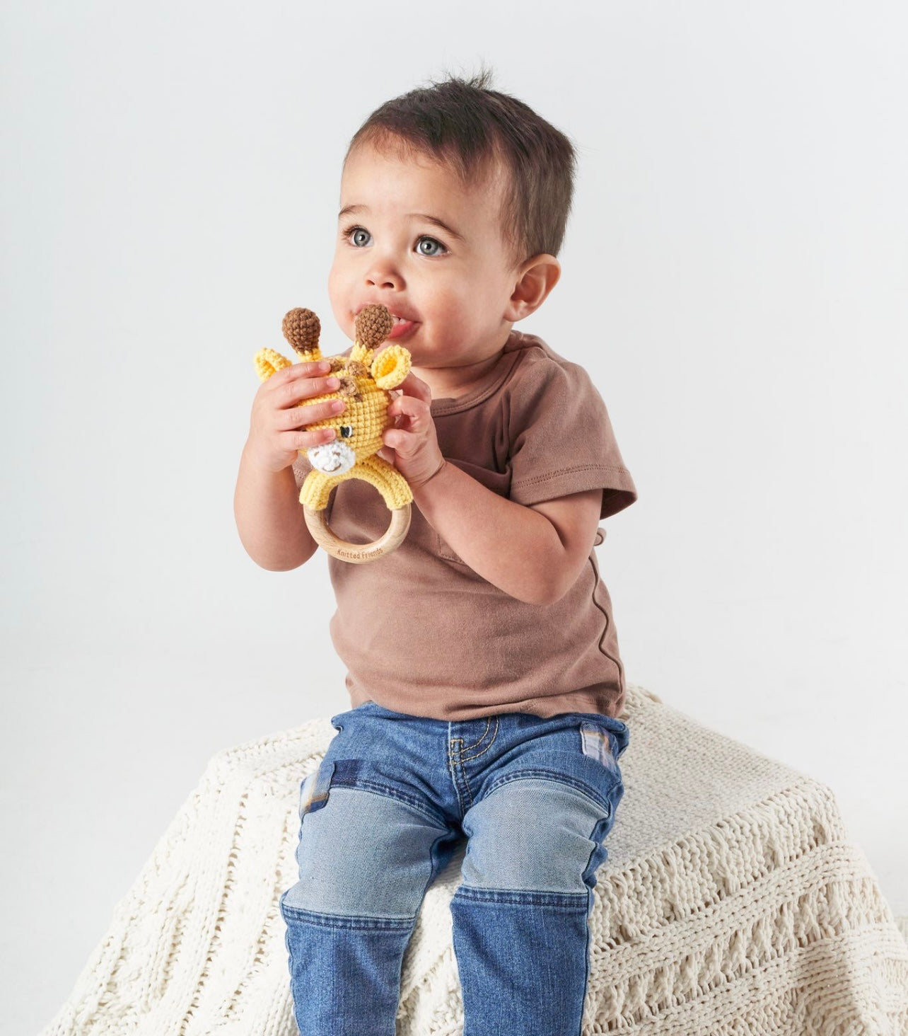 Handmade crochet giraffe rattle held by a boy