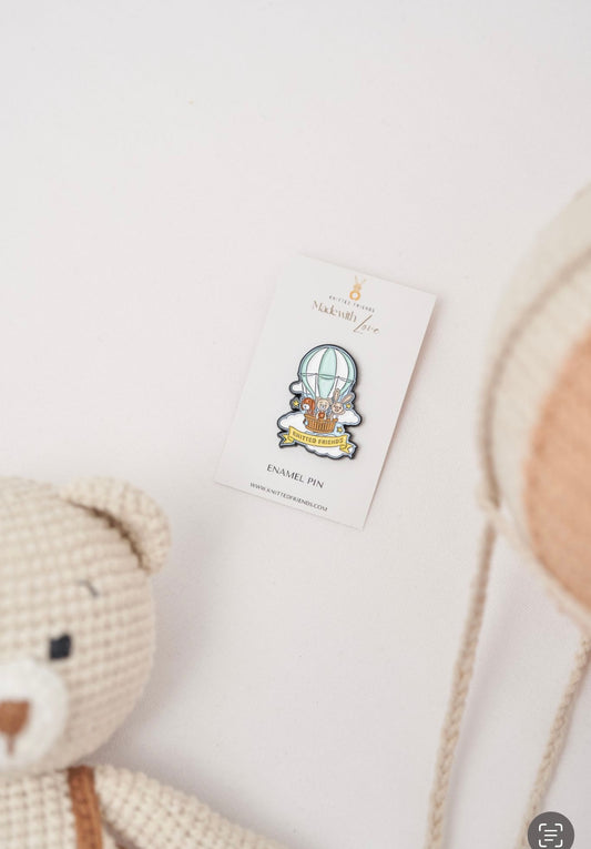Knitted Friends enamel pin on a branded card featuring a hot air balloon with animals made by Knitted Friends