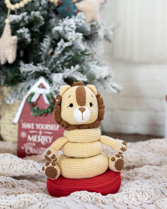 Handmade crochet lion stacking toy set by Knitted Friends displayed near the Christmas tree and wrapped gifts