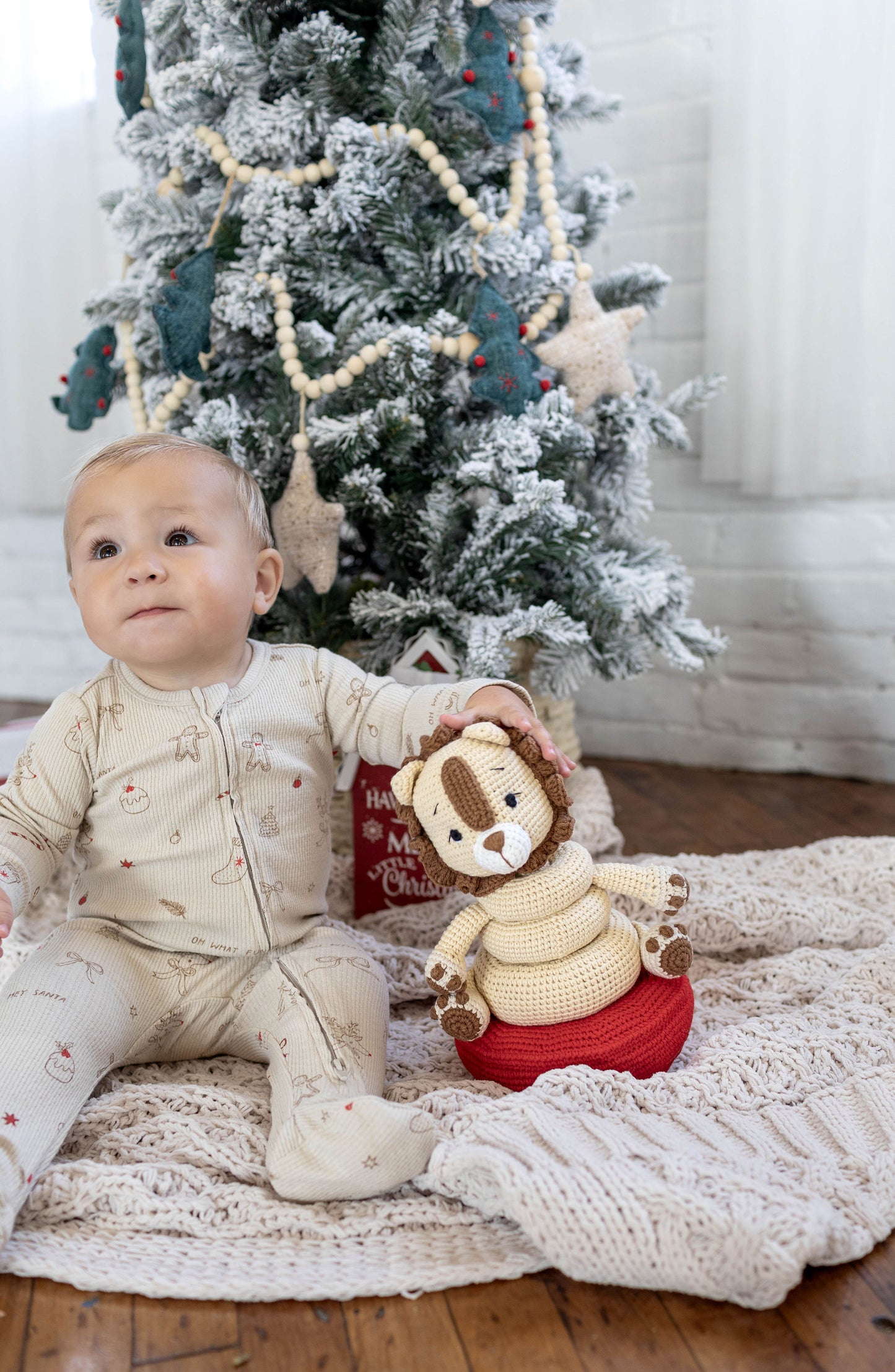 Baby playing with a handmade crochet lion stackable toy crafted by Knitted Friends