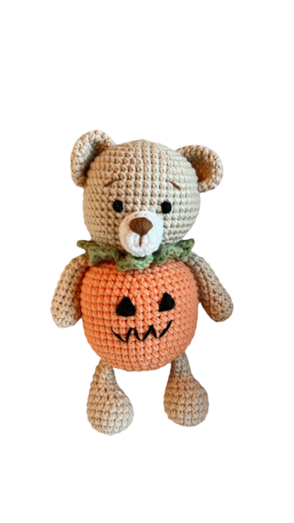 Knitted Friends pumpkin bear doll with crochet texture and Halloween pumpkin body, displayed on a black background