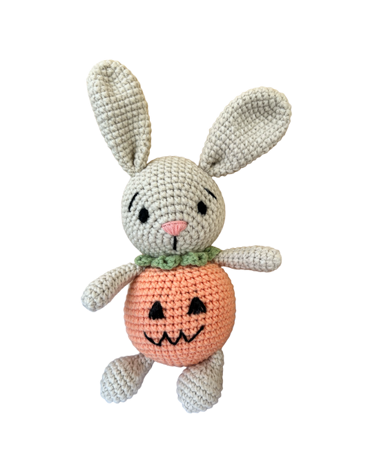 Knitted Friends pumpkin bunny doll with crochet bunny ears and pumpkin body, displayed on a black background