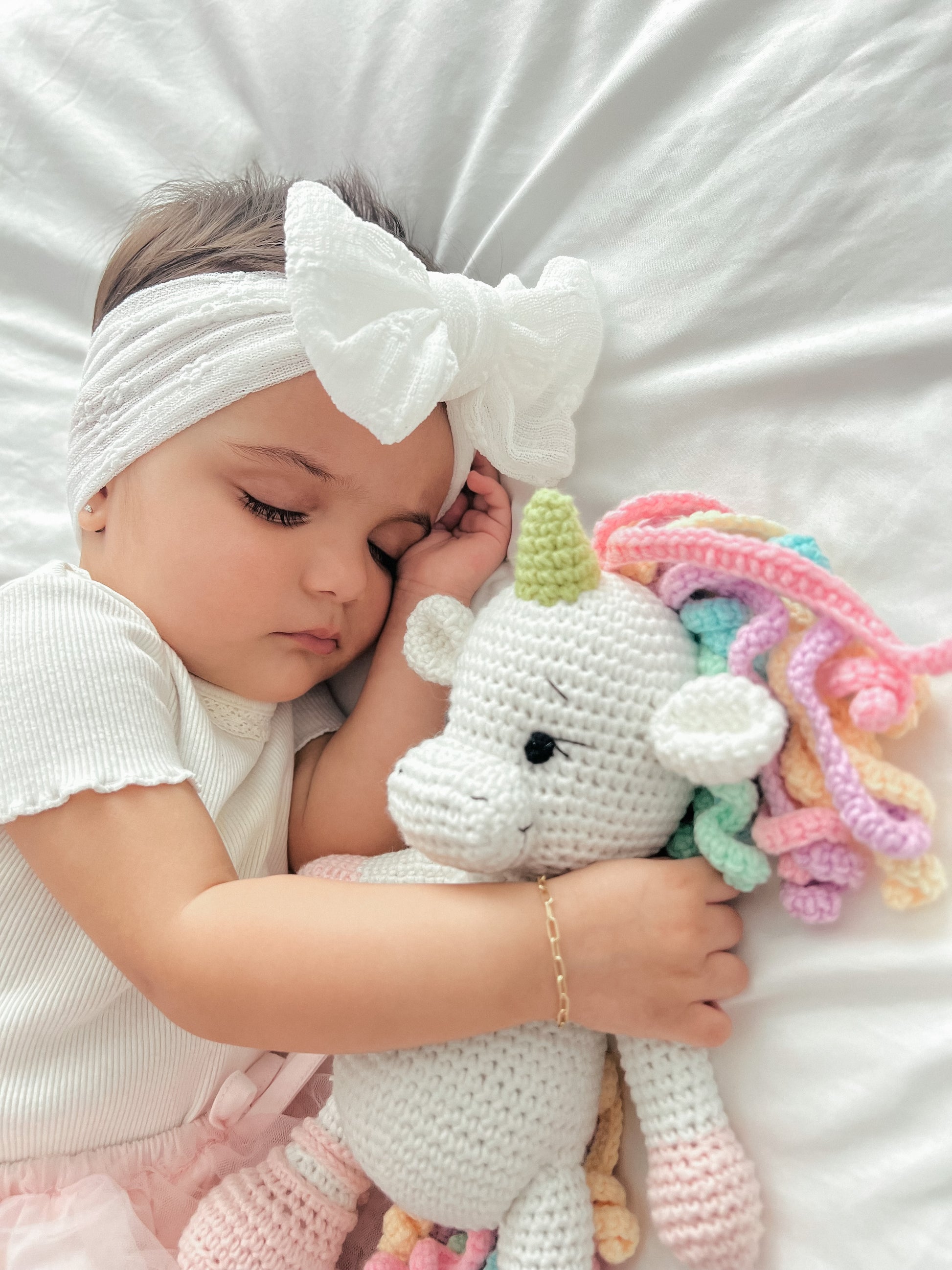 Close-up of a handmade white crochet unicorn toy doll crafted by Knitted Friends