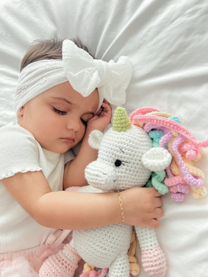 Close-up of a handmade white crochet unicorn toy doll crafted by Knitted Friends