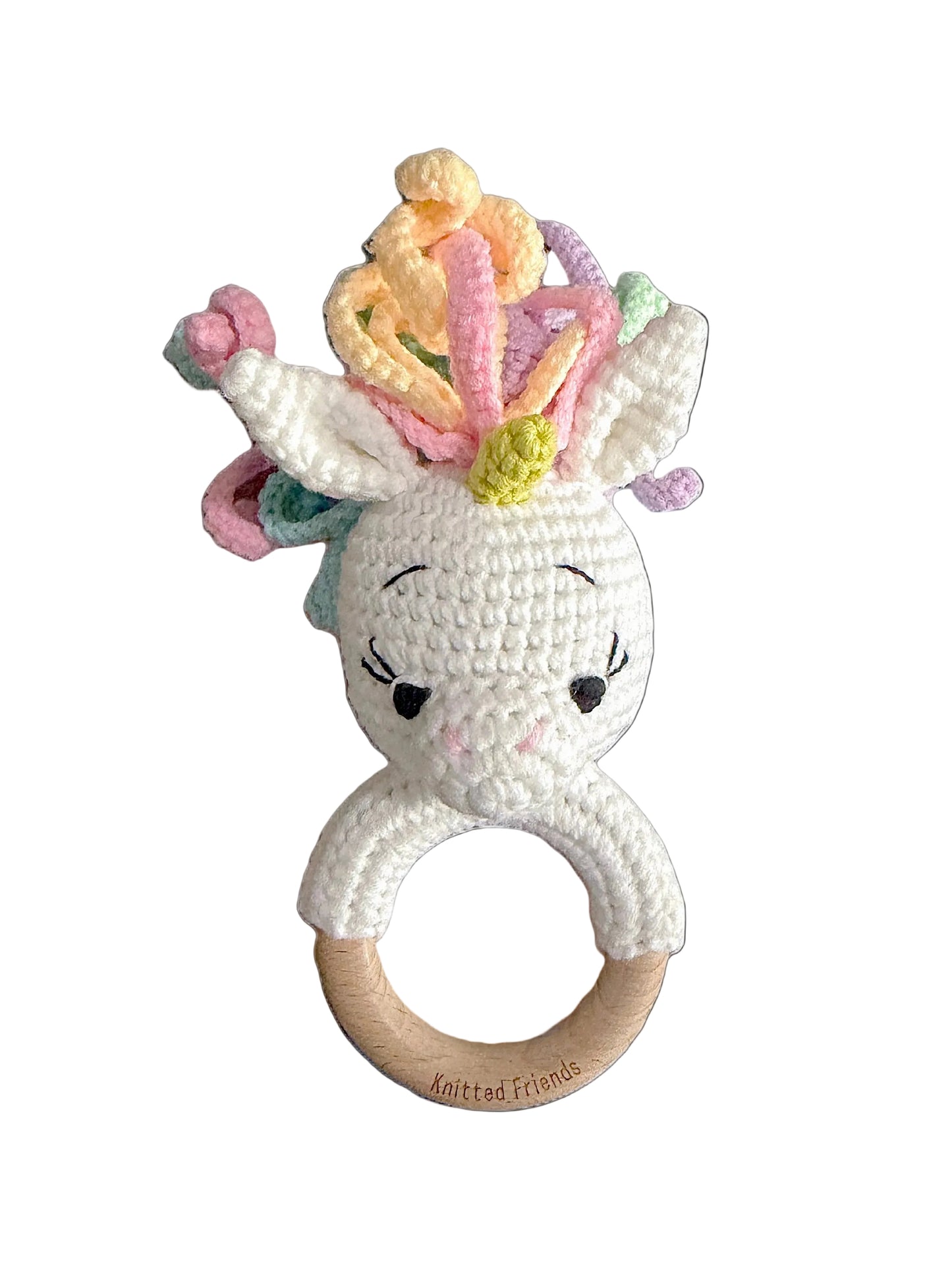 Handmade crochet unicorn teething ring with a wooden handle and colourful pastel yarn mane by Knitted Friends